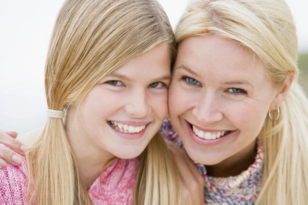 Moeder en dochter op het strand glimlachen — Stockfoto