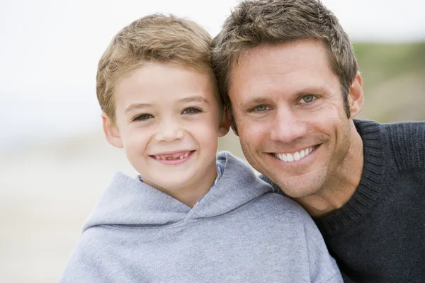 Otec a syn na pláži s úsměvem — Stock fotografie