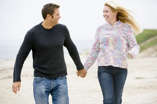 Para Spacerująca Plaży Trzymając Się Ręce Uśmiechając Się — Zdjęcie stockowe