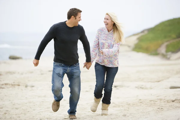 情侣在海滩牵手微笑运行 — 图库照片