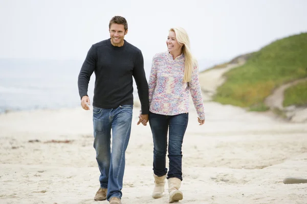 Par promenader på stranden håller hand leende — Stockfoto