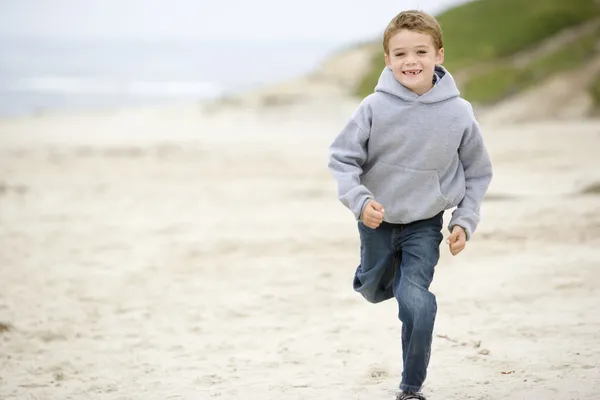 Junge läuft lächelnd am Strand — Stockfoto