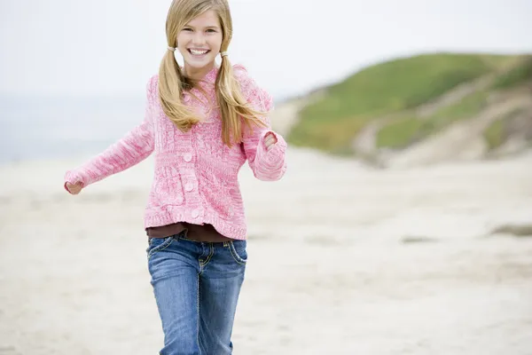 运行在海滩微笑的小女孩 — 图库照片
