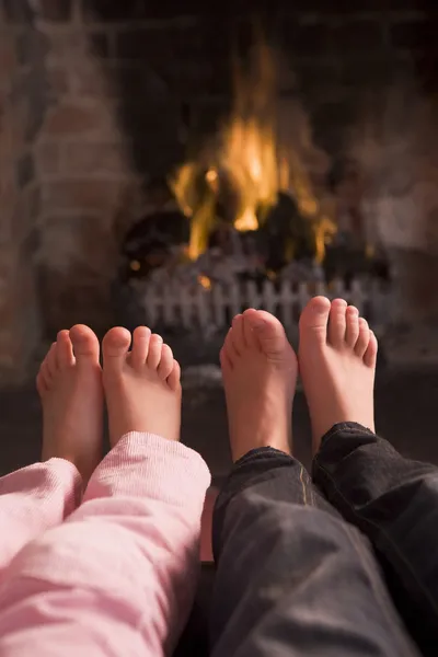 stock image Children's feet warming at a fireplace