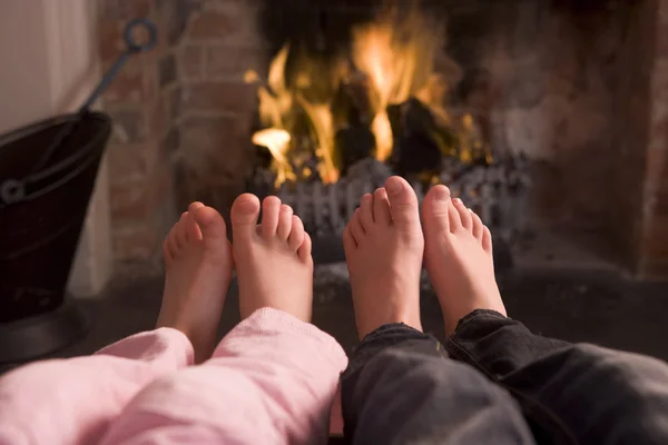 气候变暖在壁炉的夫妇的脚 — 图库照片