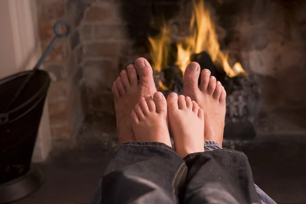 暖炉で暖まる父と息子の足 — ストック写真