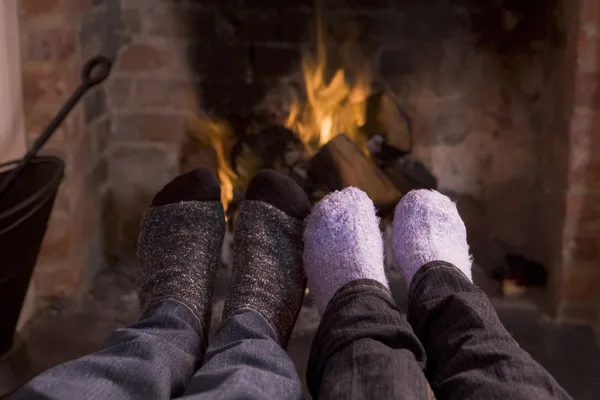 地球温暖化、暖炉でカップルのフィート — ストック写真