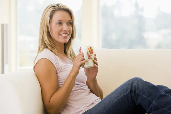 Woman in living room with coffee smiling — Stock Photo, Image