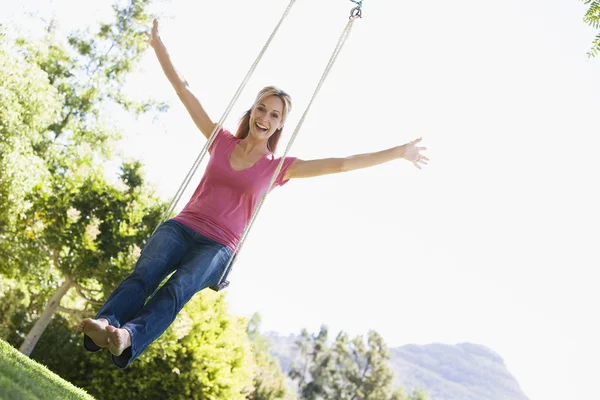 Mujer en el árbol swing sonriendo — Foto de Stock