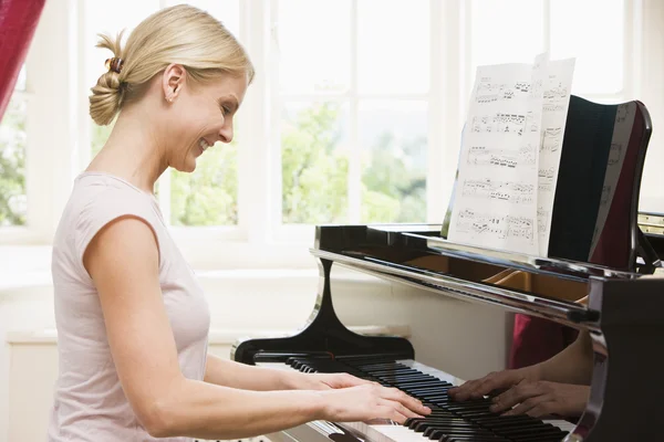 Woman playing piano and smiling — Stock Photo, Image