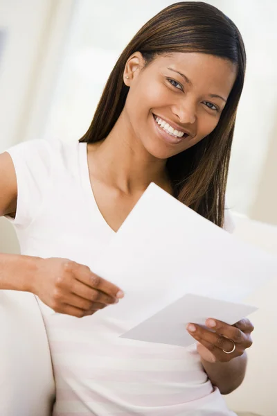Жінка Вітальні Читає Документи Посміхаючись — стокове фото