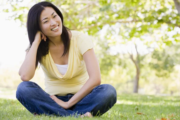 Mujer sentada al aire libre sonriendo —  Fotos de Stock