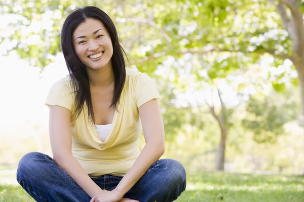 Woman Sitting Outdoors Smiling — Stock Photo, Image