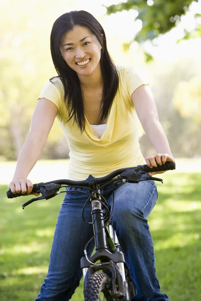 Vrouw op fiets glimlachen — Stockfoto
