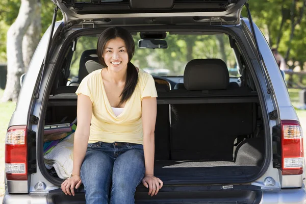 Woman sitting in back of van smiling — Stock Photo, Image