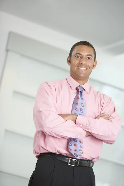 Бизнесмен, стоящий в помещении и улыбающийся — стоковое фото