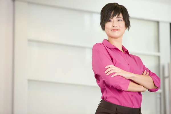 Businesswoman standing indoors smiling — Stock Photo, Image