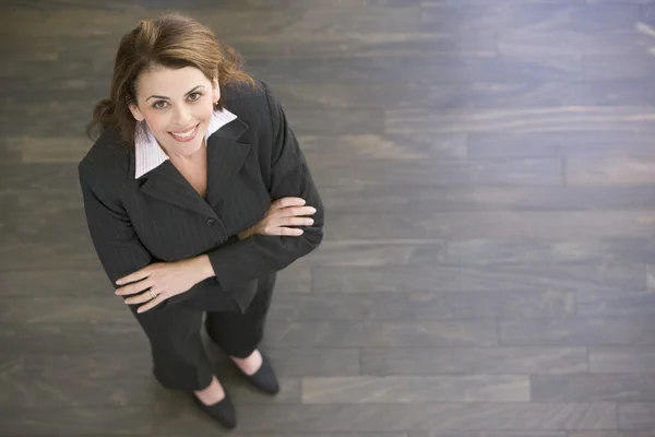 Affärskvinna som står inomhus leende — Stockfoto