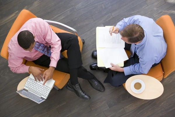 Δύο επιχειρηματίες που κάθεται στο εσωτερικό με καφέ lap-top και φάκελο — Φωτογραφία Αρχείου