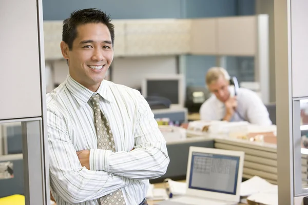 Uomo d'affari in piedi in cubicolo sorridente — Foto Stock