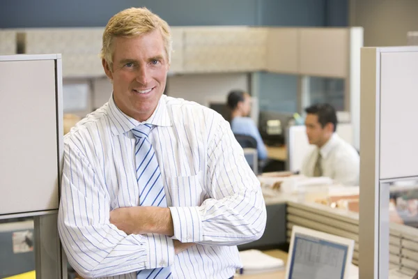 Affärsman står i elskåpet leende — Stockfoto