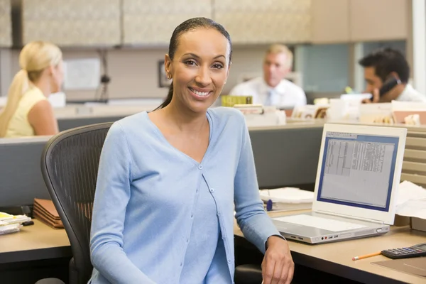 Mujer de negocios en cubículo sonriendo —  Fotos de Stock