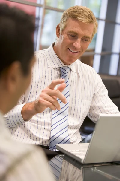 Twee zakenlieden in de directiekamer met laptop praten — Stockfoto