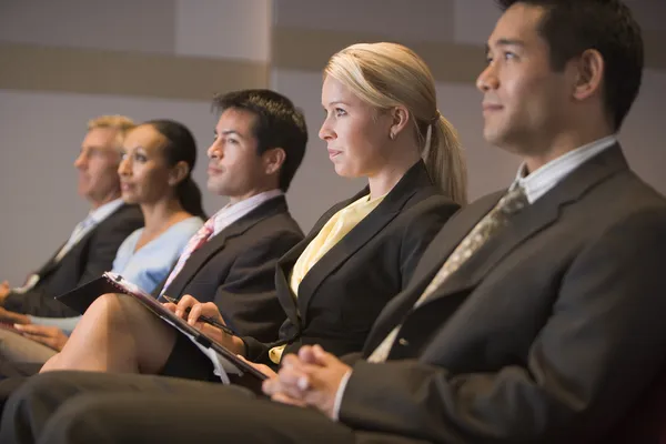 Cinco empresários sentados na sala de apresentação com pranchetas — Fotografia de Stock