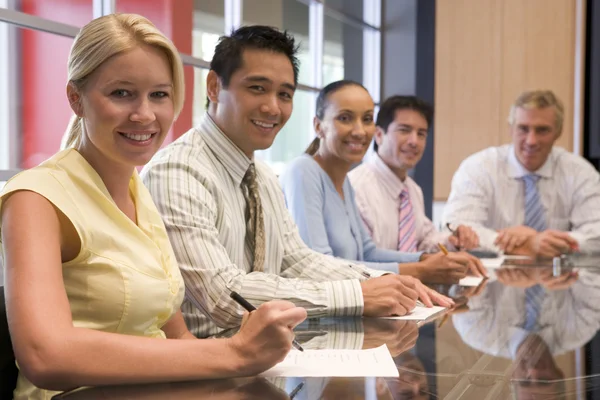 stock image Five businesspeople in boardroom smiling