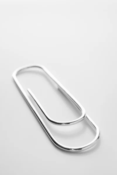Close Up de prata clipe de papel contra um fundo branco — Fotografia de Stock