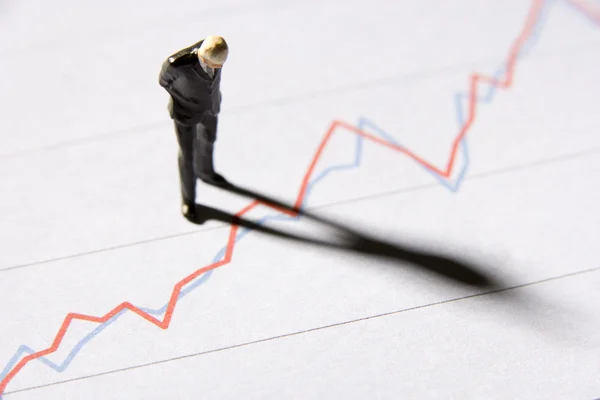 Figurinha de um empresário em pé em um gráfico de linha — Fotografia de Stock