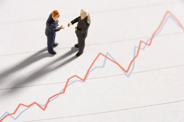 Figurines Two Businessmen Shaking Hands Line Graph — Stock Photo, Image