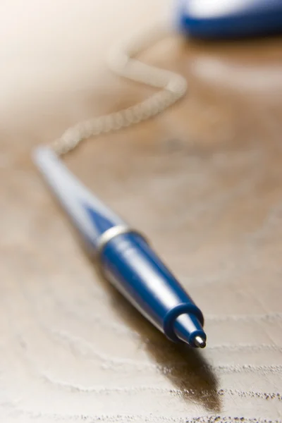 Fechar de cima caneta esferográfica azul anexada a uma corrente — Fotografia de Stock