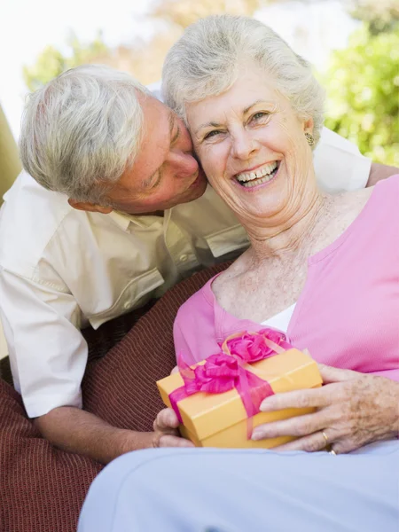 Άντρας Δίνει Δώρο Γυναίκα Στο Αίθριο Φιλάει Και Χαμογελαστός — Φωτογραφία Αρχείου