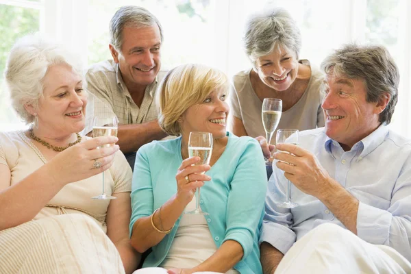 Fem vänner i vardagsrum dricka champagne och ler — Stockfoto