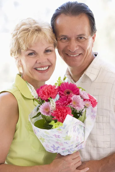 Mari et femme tenant des fleurs et souriant — Photo