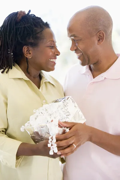 Husband and wife holding gift smiling — Stock Photo, Image