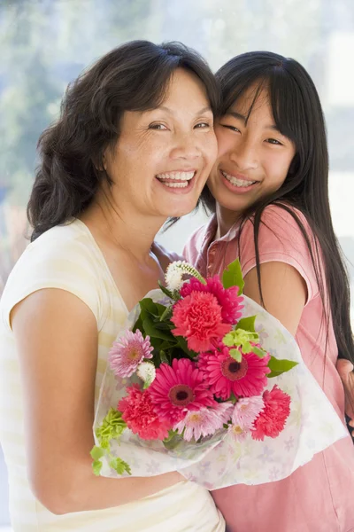 Εγγονή και γιαγιά κρατώντας λουλούδια και χαμογελαστός — Φωτογραφία Αρχείου