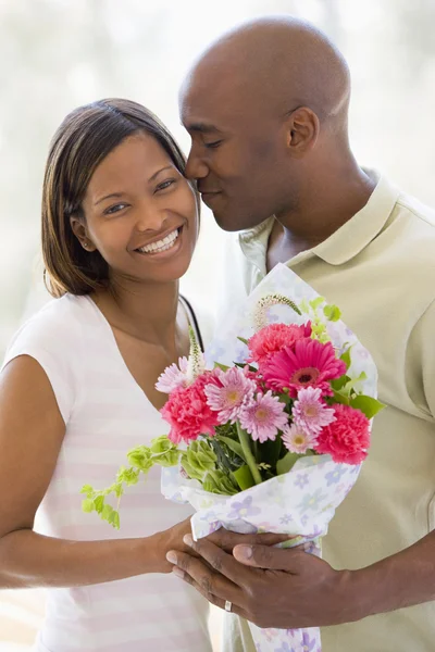 Чоловік і дружина тримають квіти і посміхаються — стокове фото