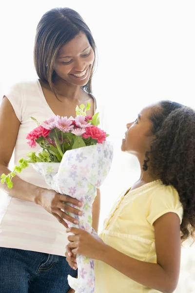 母亲给女儿鲜花和微笑 — 图库照片