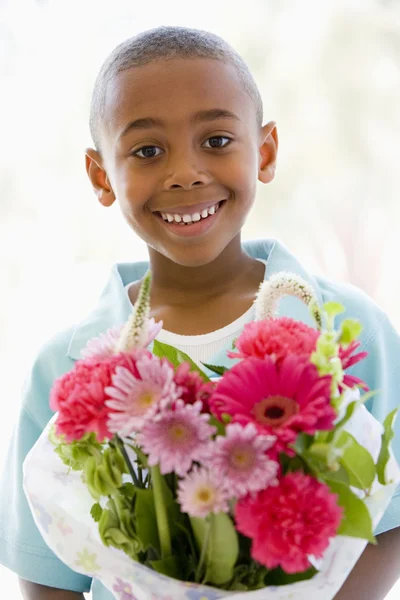 年轻的男孩抱着微笑的花朵 — 图库照片