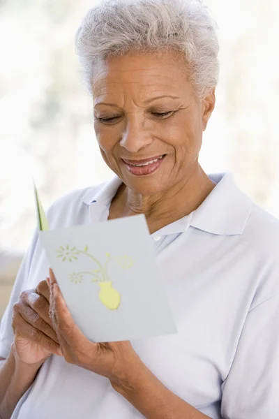 Nő-olvasó kártya és mosolyogva — Stock Fotó