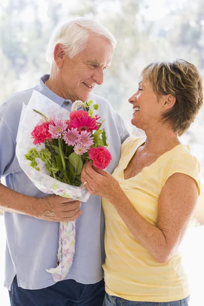 夫の妻花を与えると笑みを浮かべて — ストック写真