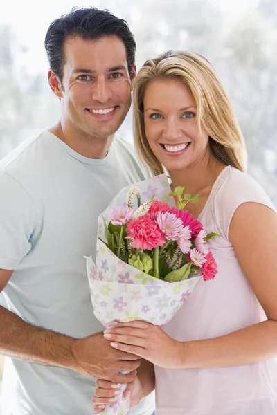 Mann und Frau halten Blumen in der Hand und lächeln — Stockfoto