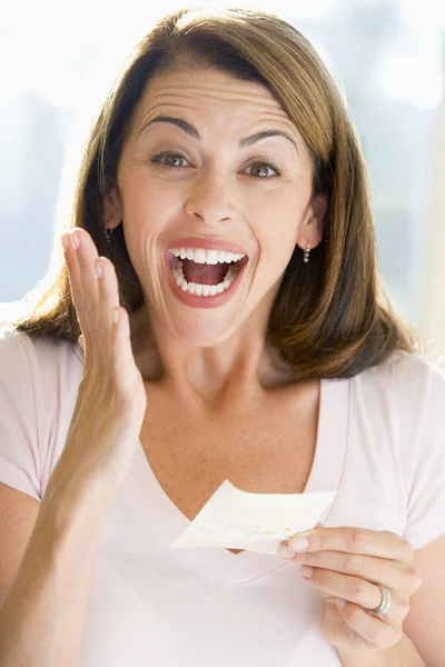 Frau mit gewinnendem Lottoschein aufgeregt und lächelnd — Stockfoto