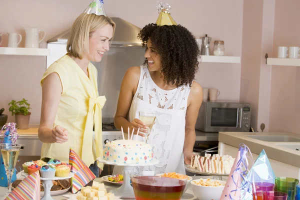 Två kvinnor på fest står vid mat bordet leende — Stockfoto