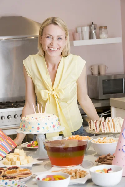 Woman at party standing by food table smiling — Stock Photo, Image