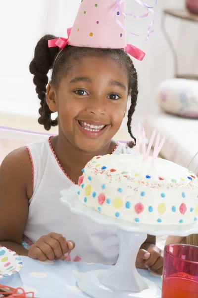 彼女の笑顔の前にケーキのパーティの帽子を着た少女 — ストック写真