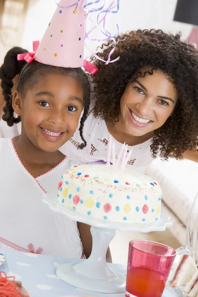 Mor och dotter med födelsedag kaka leende — Stockfoto
