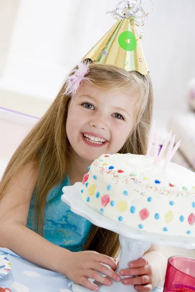 笑みを浮かべて誕生日ケーキのパーティの帽子を着ている若い女の子 — ストック写真